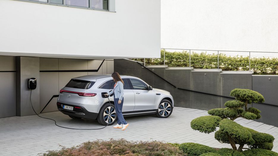 A lady charging Mercedes-Benz EQC